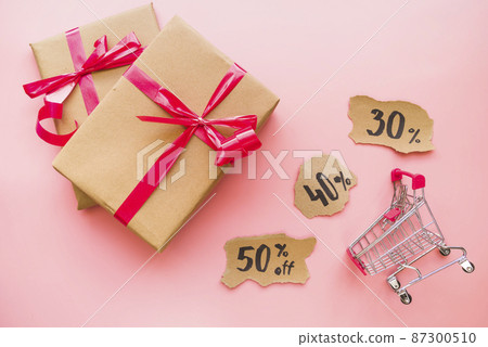 gift boxes with red bows near shopping trolley gift boxes with red bows near shopping trolley 87300510