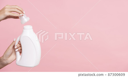 close up woman opening detergent bottle 87300609