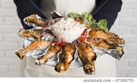 chef holding plate with chicken 87300735