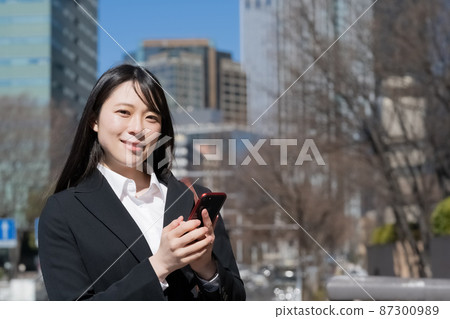 Business image of a woman looking at a smartphone Business image of a woman looking at a smartphone 87300989