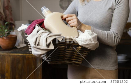 close up woman holding laundry basket 87301202