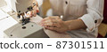 close up woman working with sewing machine 87301511