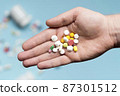 flat lay hand holding assortment pills 87301512