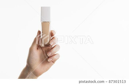 hand holding foundation bottle with copy space hand holding foundation bottle with copy space 87301513