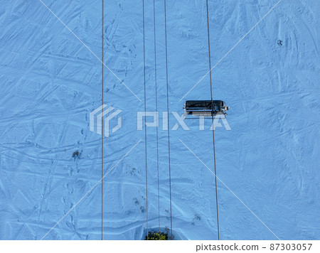 Ski lift seat and snowing mountain 87303057