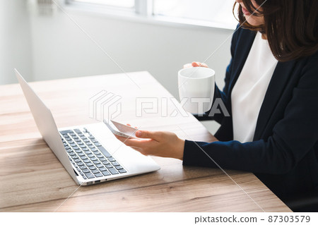 A woman who operates a smartphone while drinking coffee without a face A woman who operates a smartphone while drinking coffee without a face 87303579