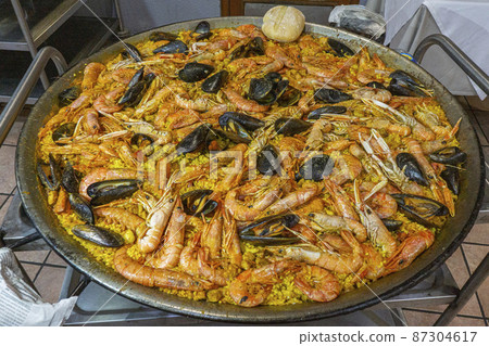 Local Spanish food Paella Valencia served in a large frying pan 87304617