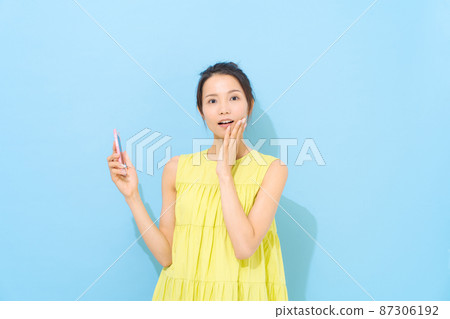 Woman holding a smartphone Woman holding a smartphone 87306192