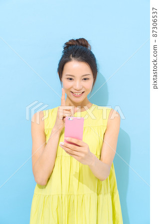 有智能手機淺藍色背景的婦女 有智能手機淺藍色背景的婦女 87306537