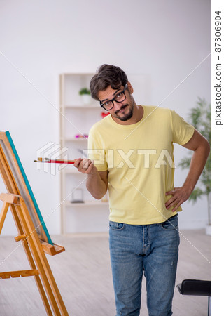 Young man enjoying painting at home 87306904