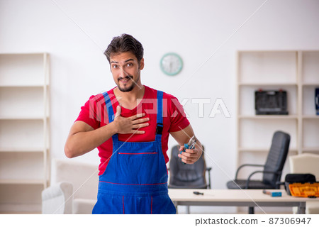 Young male repairman working at workshop 87306947