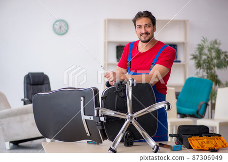 Young male repairman working at workshop Young male repairman working at workshop 87306949