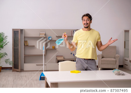 Young man doing housework at home Young man doing housework at home 87307495