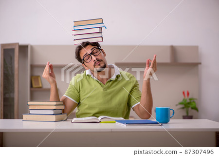 Young male student studying at home 87307496
