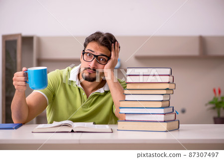 Young male student studying at home 87307497
