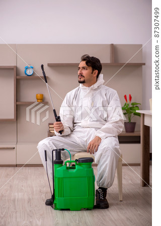 Young male contractor doing pest control at home Young male contractor doing pest control at home 87307499