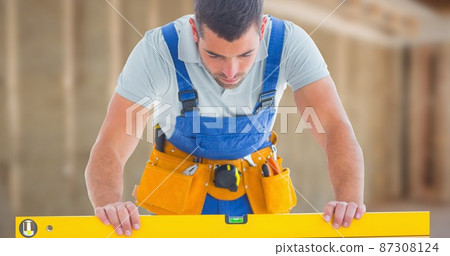 Male caucasian construction worker using level while working at side 87308124