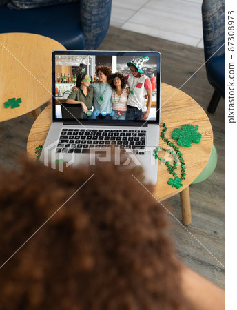 Diverse group of friends at bar on laptop screen making st patrick's day video call to friend Diverse group of friends at bar on laptop screen making st patrick's day video call to friend 87308973