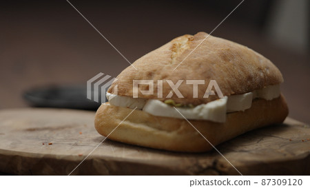 making ciabatta sandwich closeup, placing top part 87309120