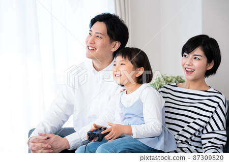 享受電子遊戲的家庭 87309820