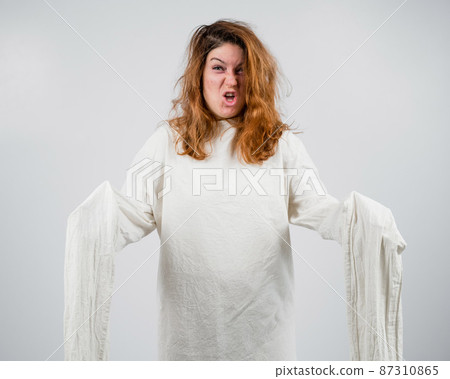Close-up portrait of insane woman in straitjacket on white background. 87310865