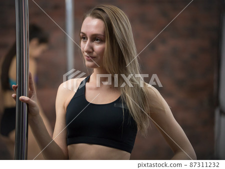 Young pretty woman in sport clothes staying next by the pole 87311232
