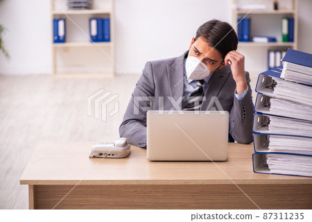 Young male employee working at workplace during pandemic Young male employee working at workplace during pandemic 87311235