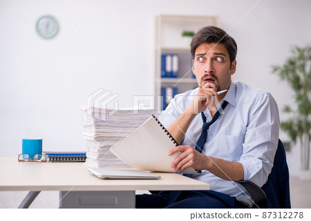 Young male employee and too much work in the office 87312278