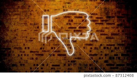 Image of glowing neon thumb down icon on brick wall 87312408