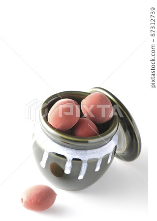 Take a picture of the crispy plums in the jar on a white background 87312739