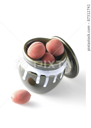 Take a picture of the crispy plums in the jar on a white background 87312741