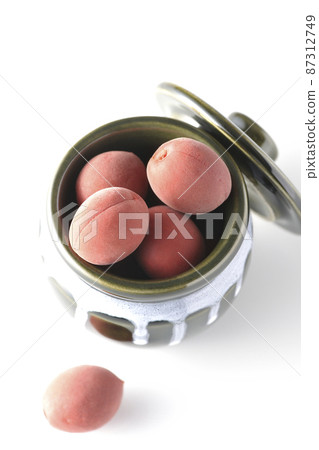A bird's-eye view of the crispy plums in the jar on a white background 87312749