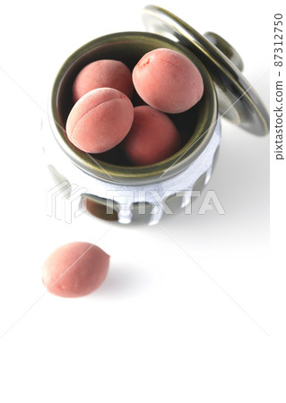 A bird's-eye view of the crispy plums in the jar on a white background 87312750