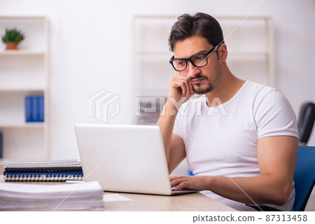 Young male student employee at workplace Young male student employee at workplace 87313458