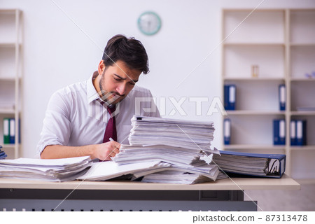 Young businessman employee unhappy with excessive work in the office 87313478