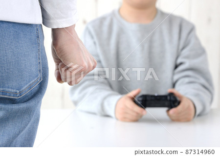At the hands of a mother who feels angry at a child who is crazy about games 87314960