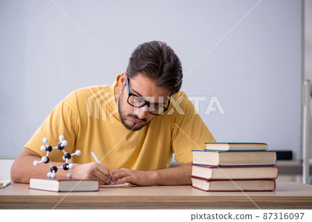 Young male student preparing for exams in the classroom 87316097