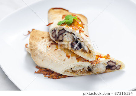 burrito filled with chicken meat and red beans 87316154