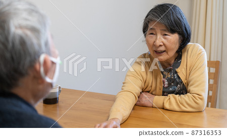 Elderly couple reaching out to their husband and listening to something Elderly couple reaching out to their husband and listening to something 87316353