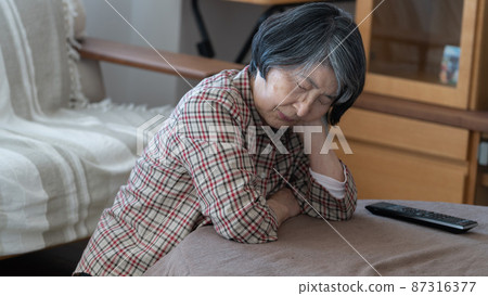 80多歲的老婦人，臉頰上掛著被爐睡覺 87316377