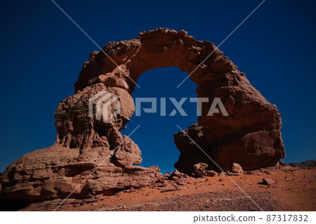 Arch Rock formation aka Arch of Africa or Arch of Algeria with moon at Tamezguida in Tassili nAjjer national park in Algeria 87317832