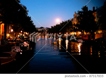 Night view to Amsterdam canal with moon, Netherlands 87317833