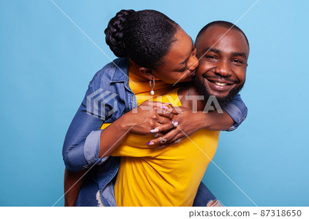Cheerful man and woman having fun with piggyback ride 87318650