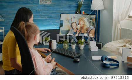 Mother and daughter using video call for conversation with friends 87318815