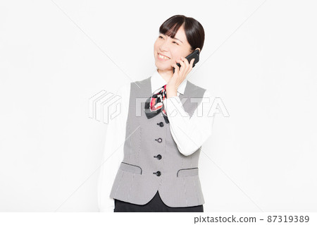 站在白色背景前並使用智能手機的女商人 站在白色背景前並使用智能手機的女商人 87319389