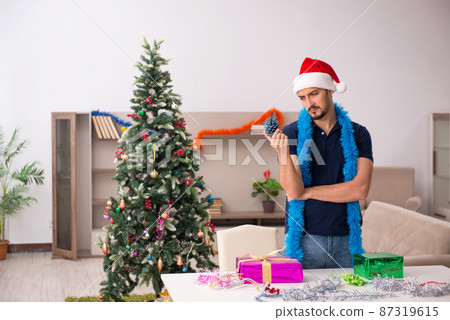 Young man celebrating Christmas at home Young man celebrating Christmas at home 87319615