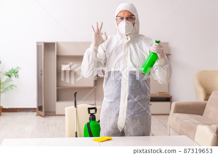 Young male contractor doing pest control at home 87319653