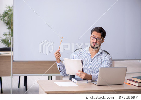 Young male teacher in the classroom Young male teacher in the classroom 87319697