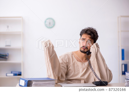 Crazy young man in straitjacket at the office 87320166