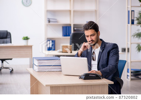 Young handsome employee working in the office 87320802